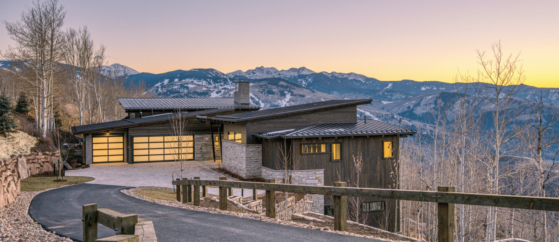 Luxury mountain home in Vail Valley built by H&C Construction, featuring floor-to-ceiling windows, modern stonework, and a snow-covered landscape