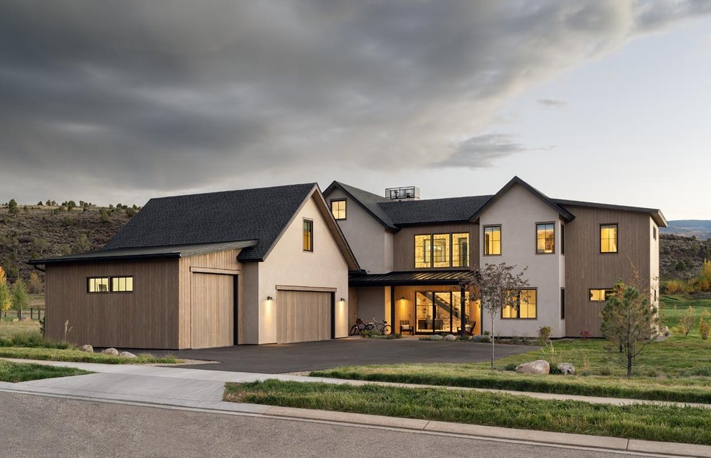 Contemporary farmhouse-style home in Eagle Ranch, Colorado built by H&C Construction, featuring wood accents, neutral stucco siding, and a spacious three-car garage